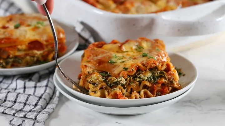Vegetarian Spinach Lasagna 20 Vegetarian spinach lasagna featuring layers of spinach, cheese, and marinara sauce in a baking dish.