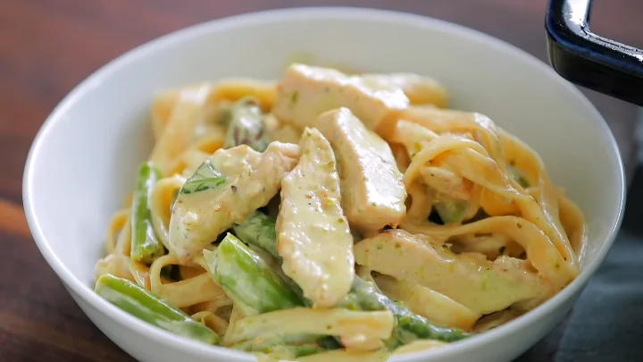 Italian chicken pesto pasta salad 17 A delicious serving of Italian chicken pesto pasta salad, showcasing pasta, chicken, and fresh veggies mixed with pesto.